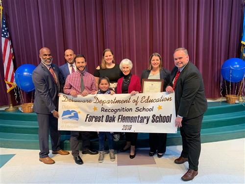 Secretary Bunting, Superintendent Green and school staff with student 